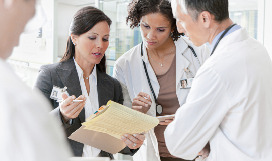 Intrinsiq_Specialty_Solutions_MIPS_consultant_speaking_with_group_of_doctors